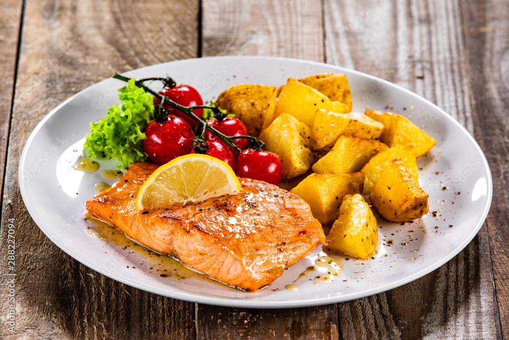 Fried salmon with baked potatoes and vegetables