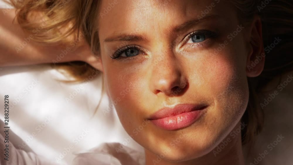 Blonde Woman Lying on Bed Opening Her Eyes with Sun Beaming Down Her Face Blonde Woman Lying on Bed Opening Her Eyes with Sun Beaming Down Her Face