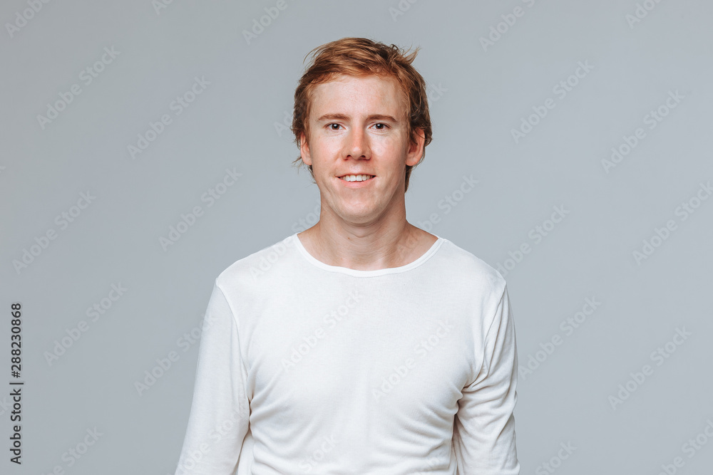 Fototapeta premium Red-haired man in a white jacket on a light gray background