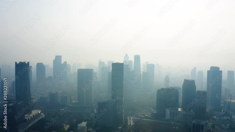 JAKARTA, Indonesia - September 04, 2019: Beautiful aerial view of air pollution fog and skyscrapers on the morning. Shot in 4k resolution from a drone flying down JAKARTA, Indonesia - September 04, 2019: Beautiful aerial view of air pollution fog and skyscrapers on the morning. Shot in 4k resolution from a drone flying down