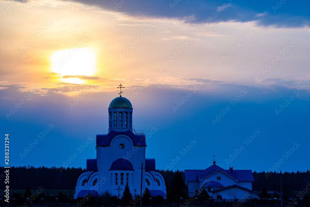 Small village church on a sunset background.