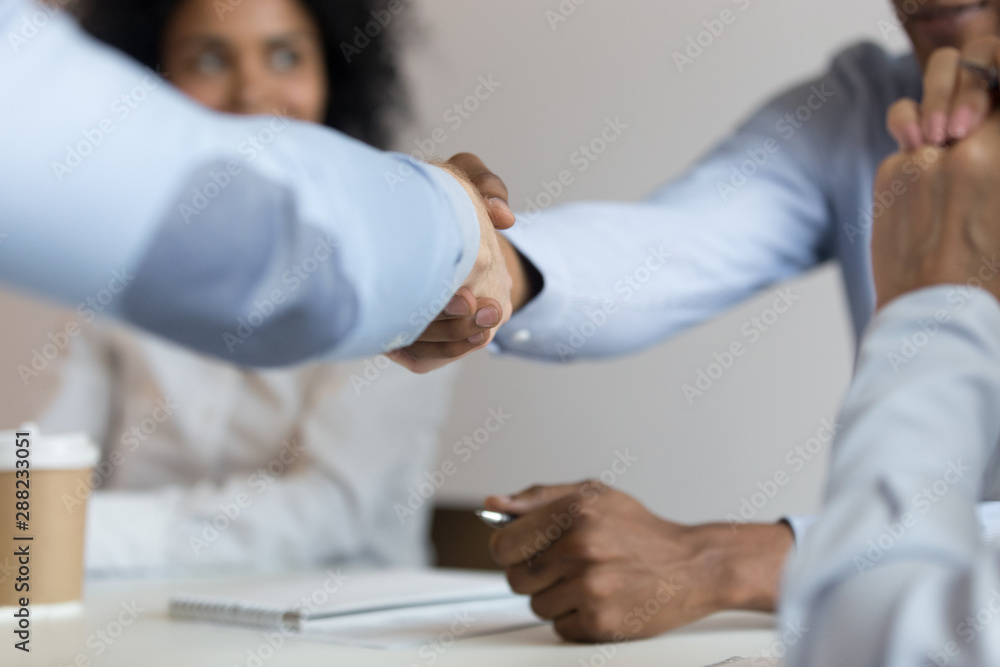 Close up of male colleagues handshake at business negotiations Close up of male colleagues handshake at business negotiations