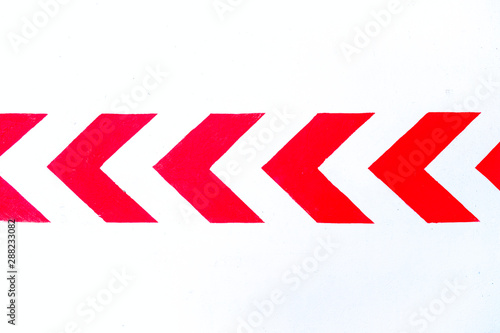 Bold red arrows reflective paint on white reflective background, road markings, flash gun artificial light.