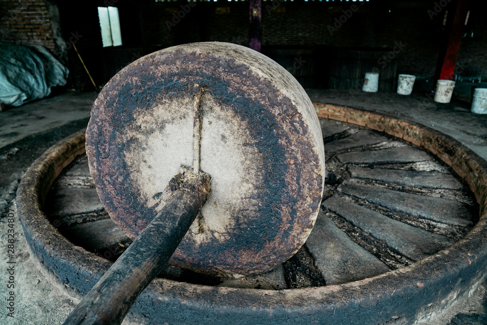 Empty grungy large mill press at traditional distillery in daylight