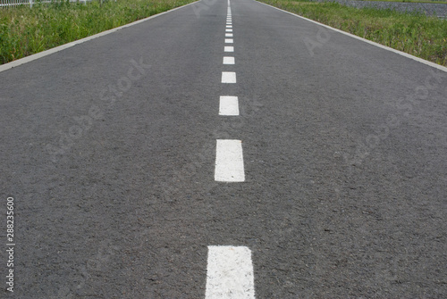 Dark asphalt road with marking lines. Tarmac texture