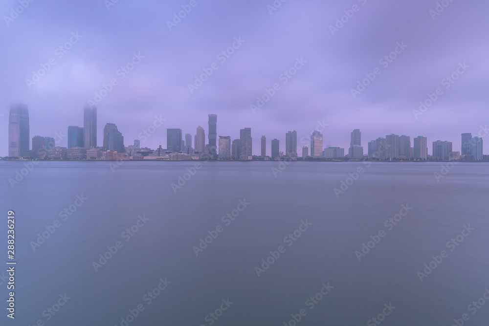 Jersey city from Hudson river on a foggy morning