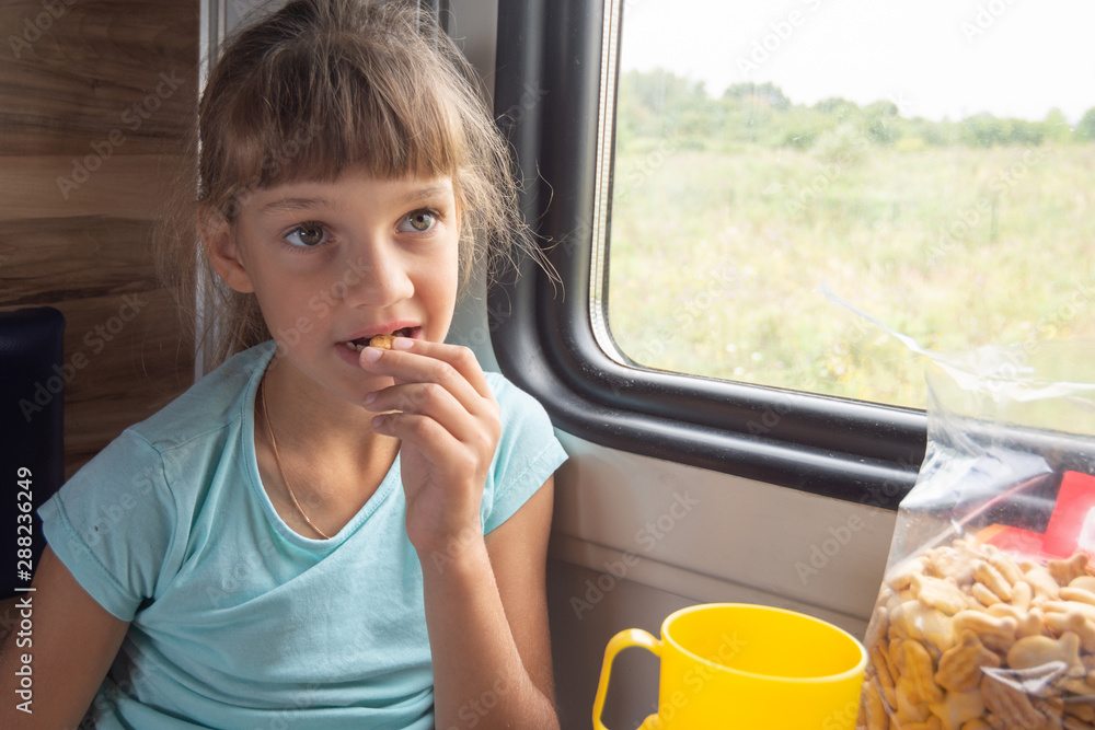 Fototapeta premium Girl eats cookies in a train