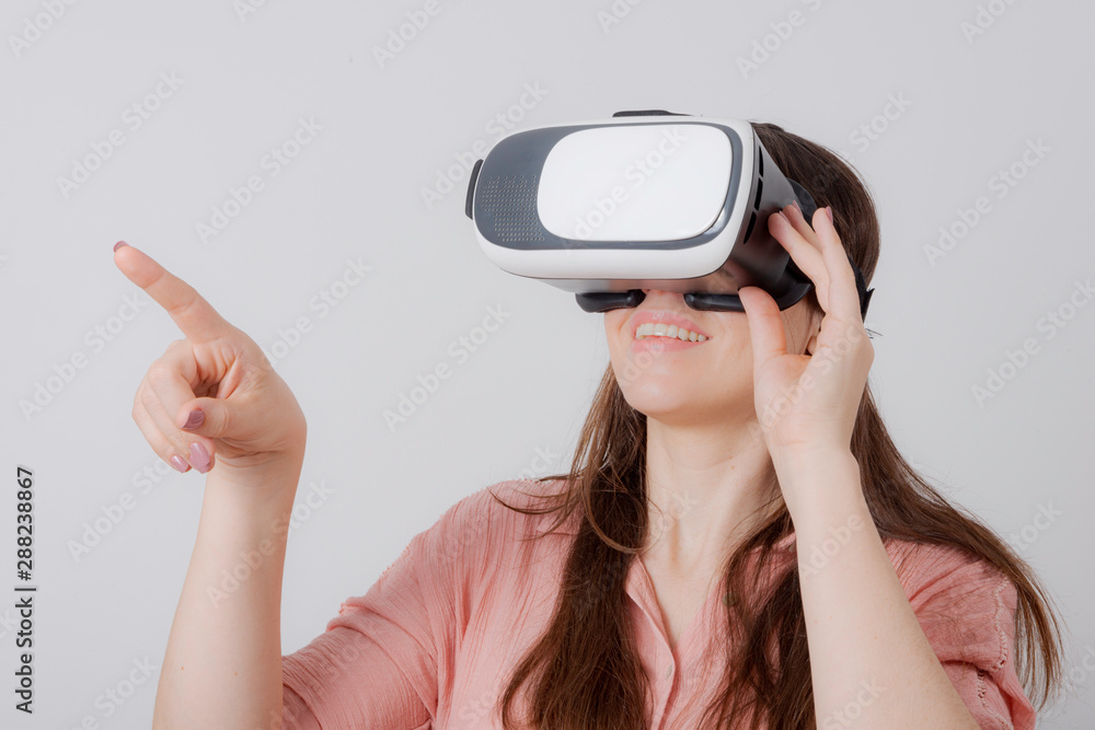 Woman using VR on white background pointing to something. Woman using VR on white background pointing to something.