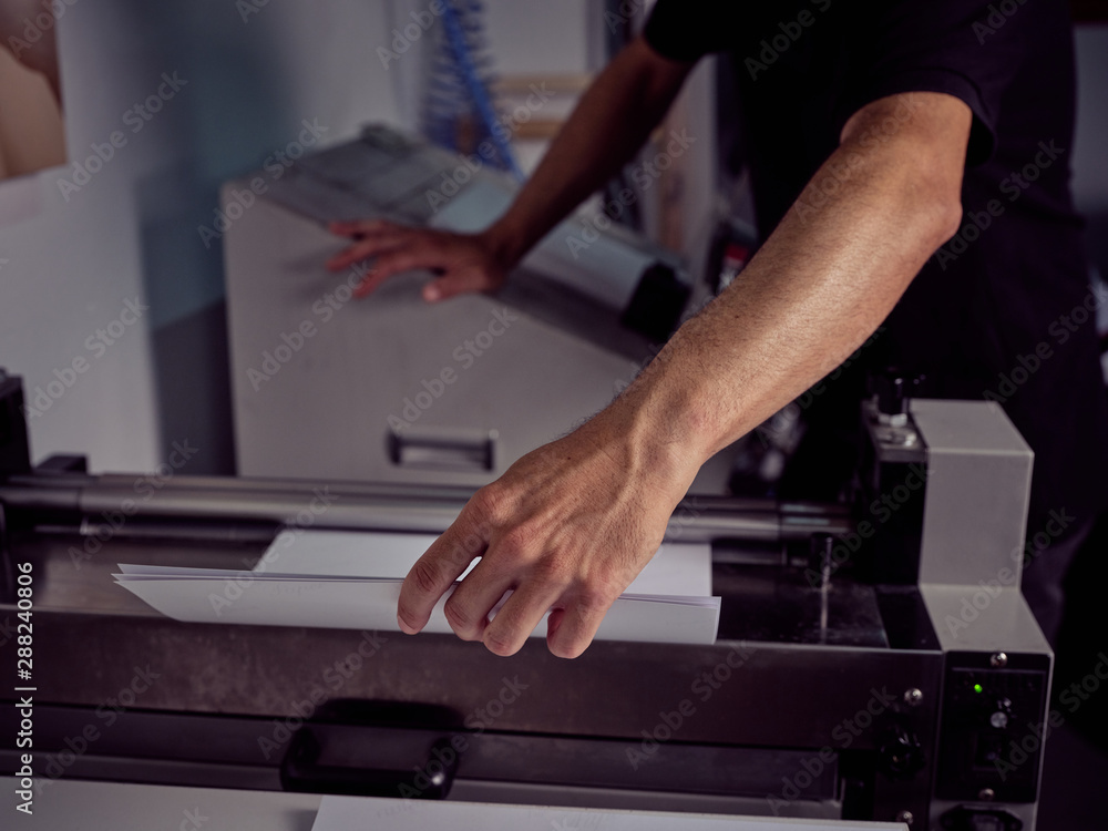 Unrecognizable worker using pressing machine in printing house Unrecognizable worker using pressing machine in printing house