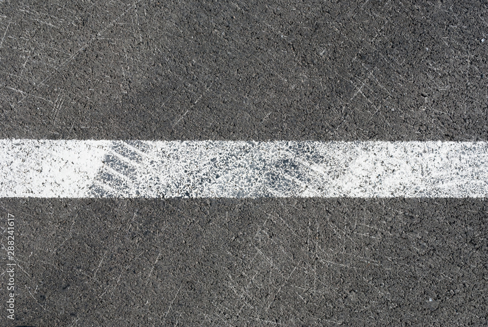 Fototapeta premium Asphalt texture with white line and tire marks . Top view