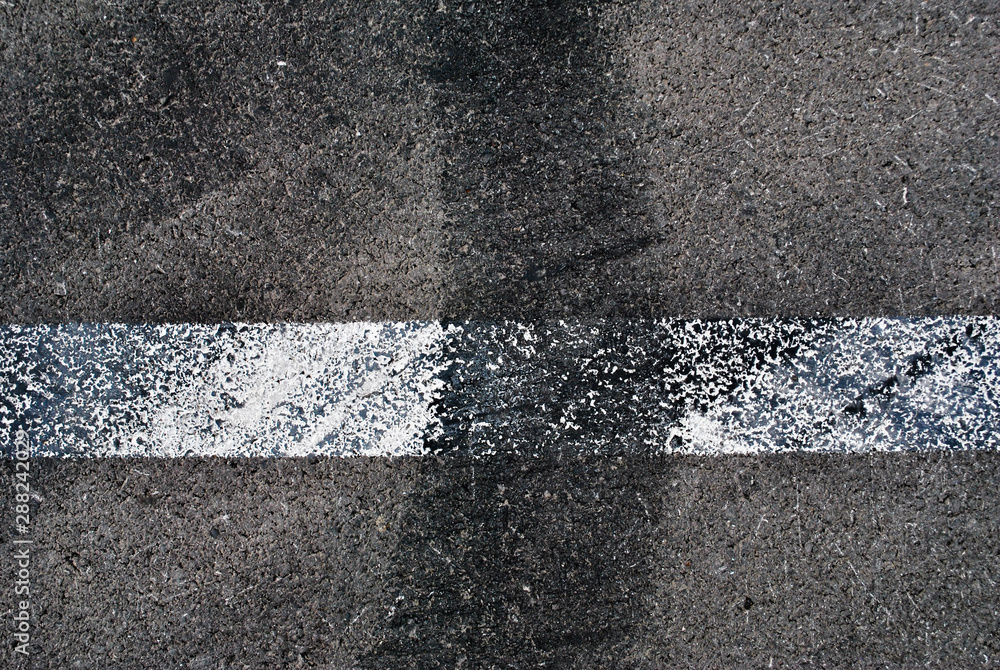 Fototapeta premium Asphalt texture with white line and tire marks . Top view
