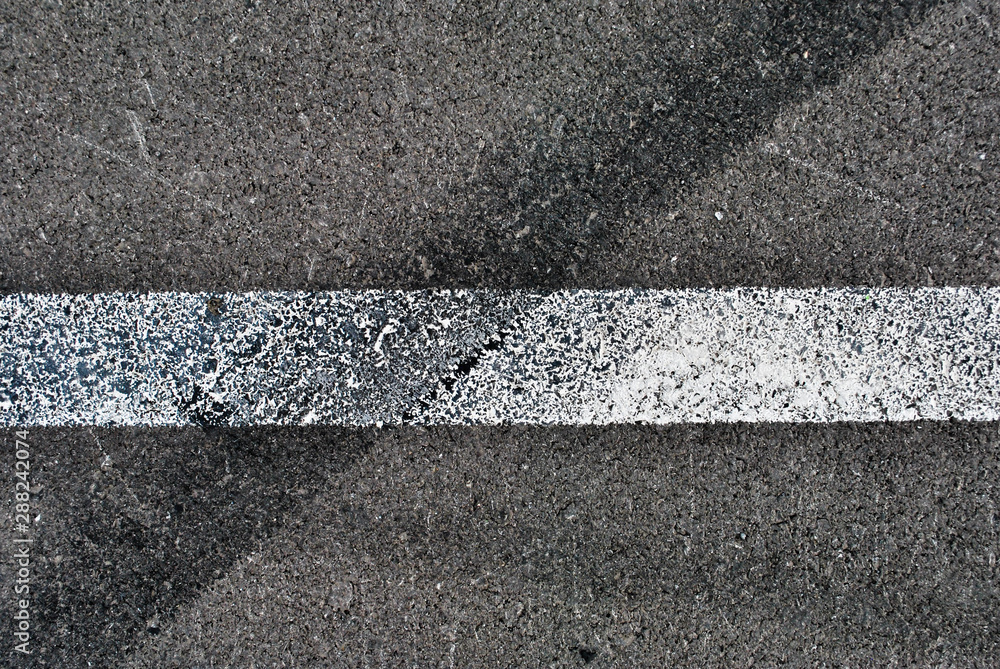 Fototapeta premium Asphalt texture with white line and tire marks . Top view