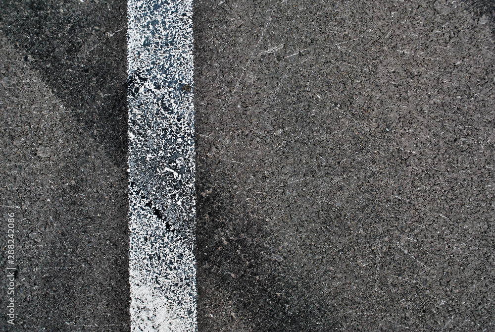 Fototapeta premium Asphalt texture with white line and tire marks . Top view