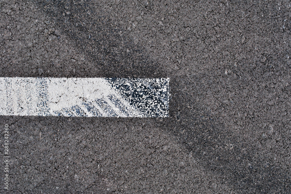Fototapeta premium Asphalt texture with white line and tire marks . Top view