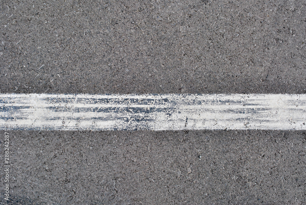 Fototapeta premium Asphalt texture with white line and tire marks . Top view