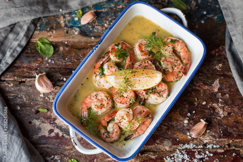 Lemon garlic butter shrimp on wooden background