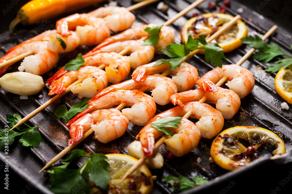 Closeup of prawns Shrimps roasted on pan with lemon, garlic and herbs.