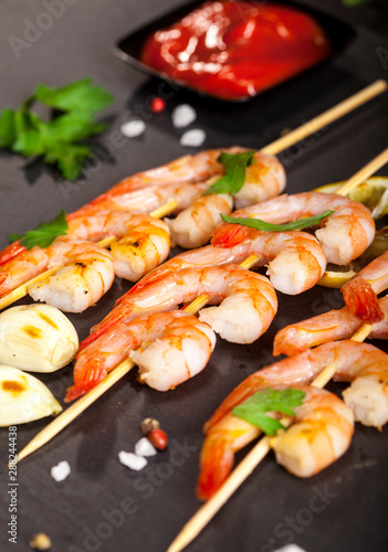 Prawns Shrimps with lemon, garlic and herbs on black background. Closeup