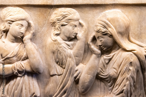 Ancient carved statues on marble showing group of women thinking