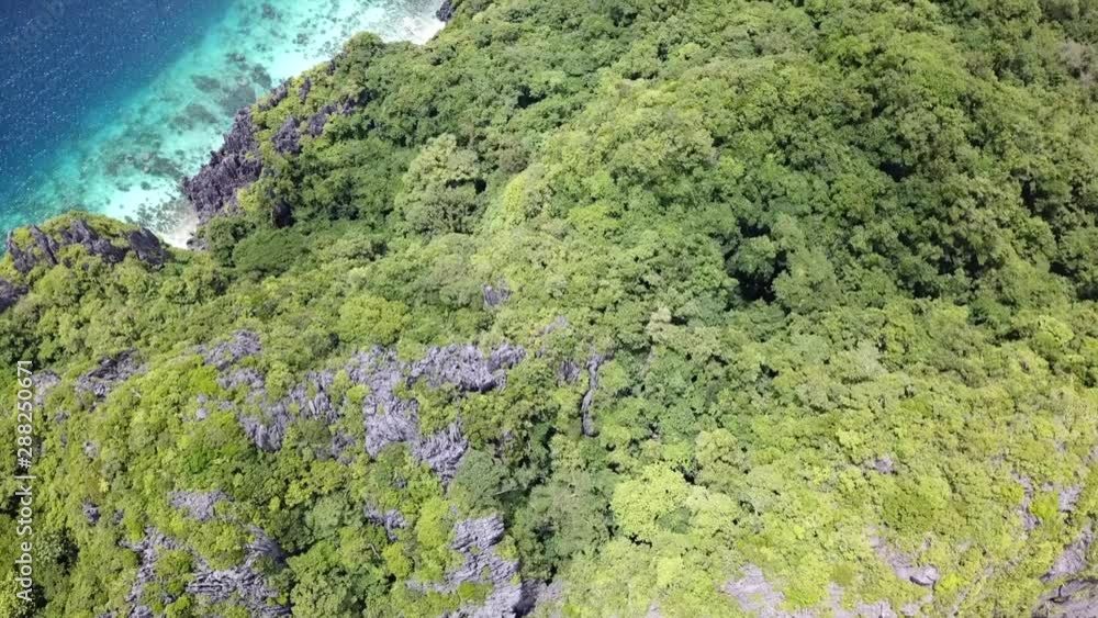 Top down aerial view of beautiful green overgrown rocks and turquoise waters on the beach shore. Philippines Top down aerial view of beautiful green overgrown rocks and turquoise waters on the beach shore. Philippines