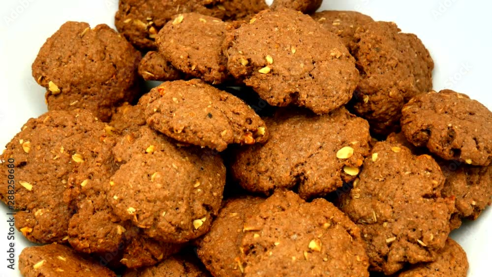 Chocolate homemade cookies with nuts, falling into a large white bowl Chocolate homemade cookies with nuts, falling into a large white bowl