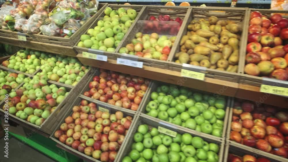 Many different fruits in the store on the shelves. Camera spans along racks Many different fruits in the store on the shelves. Camera spans along racks