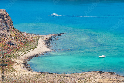 Boats near the rocky coastline of blue lagoon in Crete  Greece.
