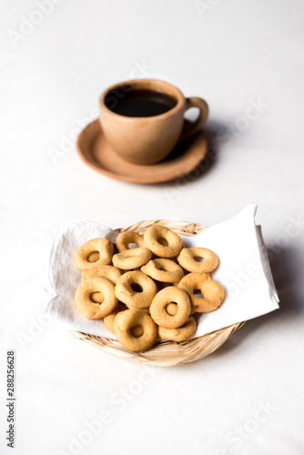 Rosquillas served in a handmade palm tray accompanied by a cup of coffee. Nicaraguan breakfast. White background without people. © mariag_foto