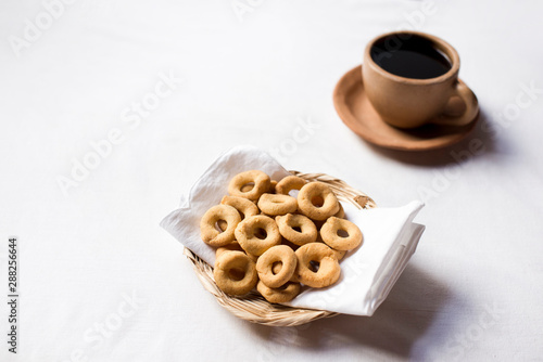 Rosquillas served in a handmade palm tray accompanied by a cup of coffee. Nicaraguan breakfast. White background without people.