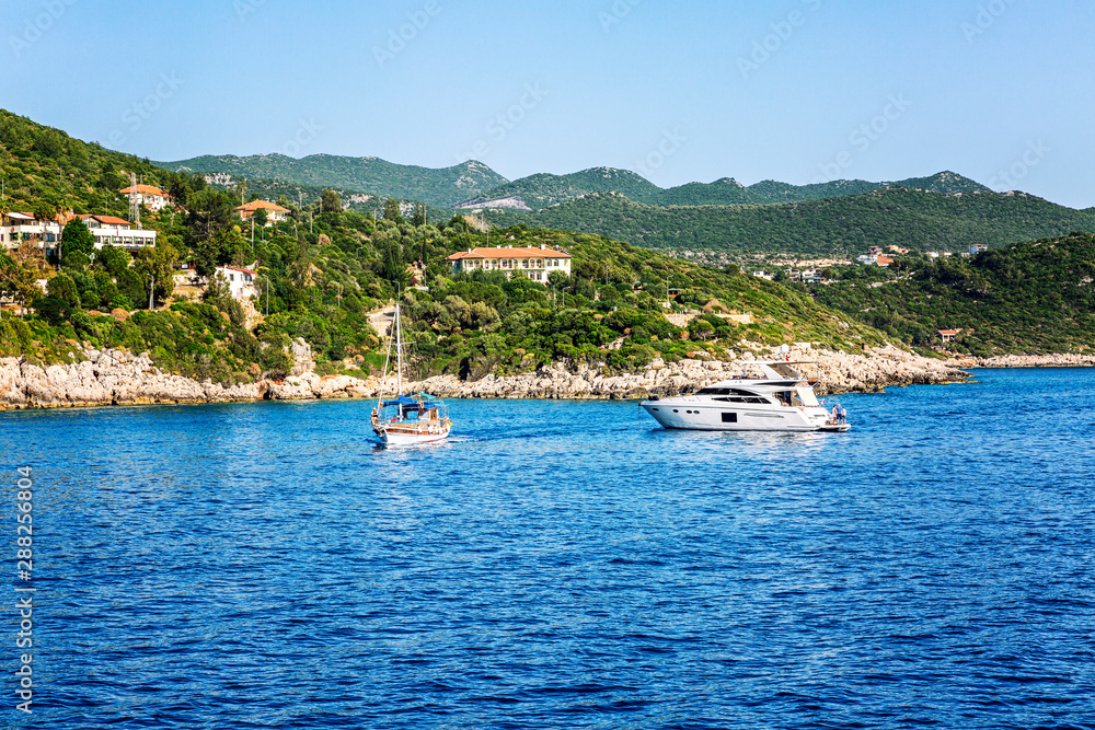 Yachts in the sea with beautiful views of the landscape on the shore on a sunny day.