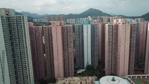 Tilt Up Aerial of Hong Kong Tall Residental Buildings in Kowloon East. Famouus Asian Metropolis and Harbor on Cloudy Day photo