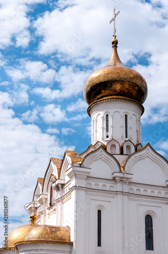 The Golden dome of the Church of the Holy Martyr Grand Duchess Elisabeth in Khabarovsk in the summer against the blue sky and clouds photo