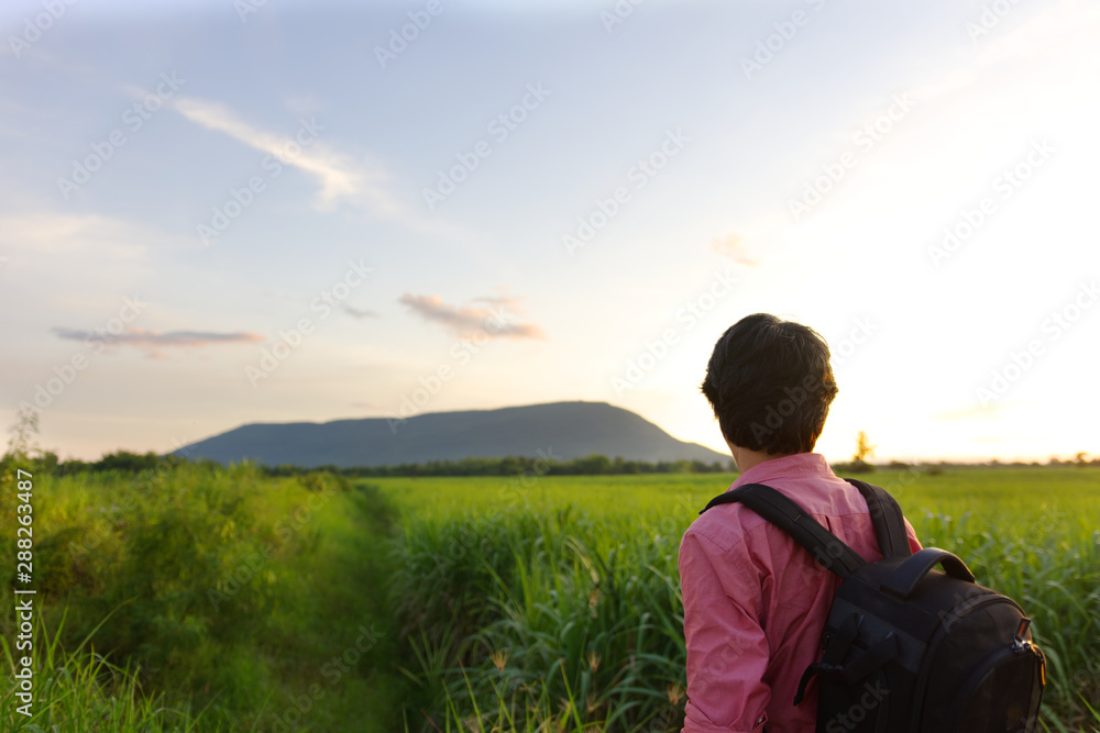 partial of man carry bag looking at the far away mountain.