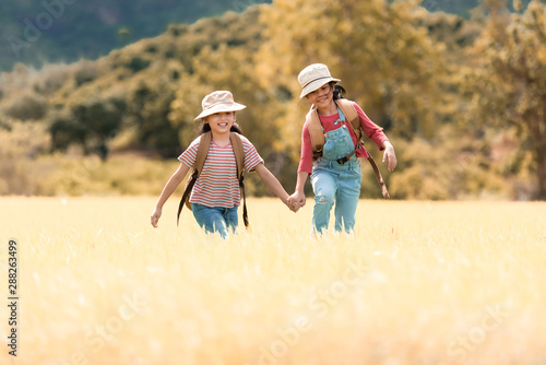 Asian girl and friend running and enjoy in the field meadows outdoors, adventure and tourism for destination leisure trips for education and relax in nature park. Travel vacations and Life Concept