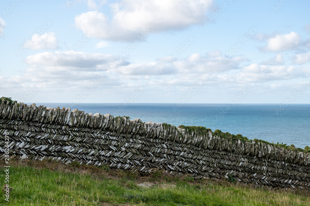 Fototapeta premium Cloudscape over dry stone wall