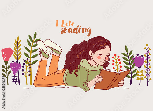 Cute little girl reading a book in the garden