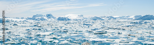Fotografie Global Warming and Climate Change - Icebergs and ice from melting glacier in icefjord in Ilulissat, Greenland