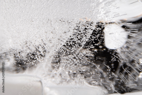 Macro close up detail of bubbles in ice cube on dark background