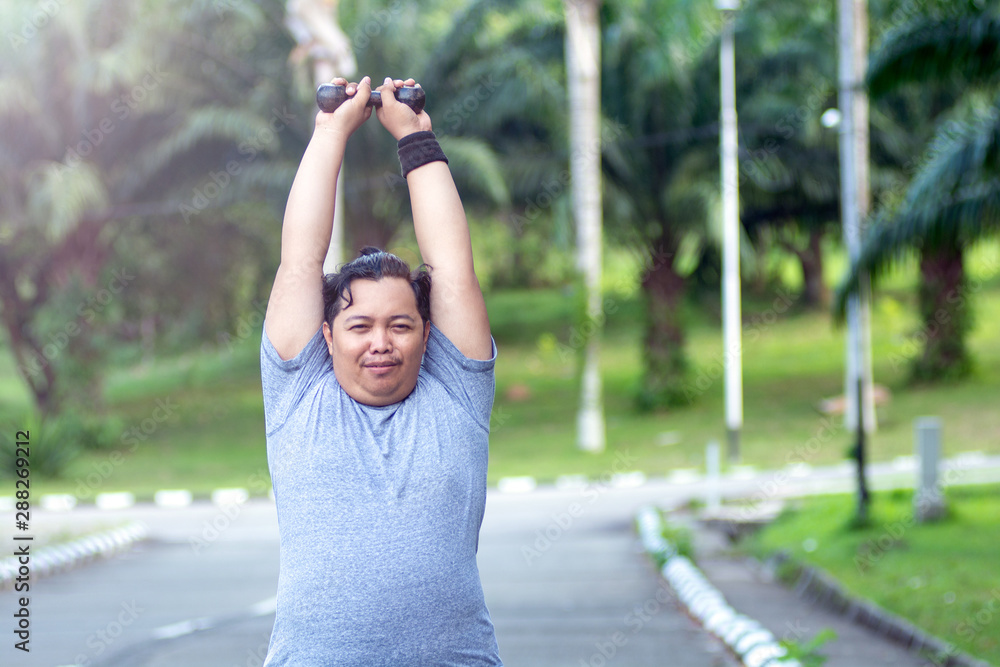 Asian young men with obesity trying to lose weight with barbell exercises and feel not strong Asian young men with obesity trying to lose weight with barbell exercises and feel not strong