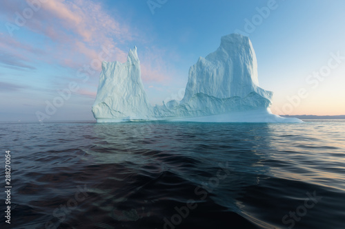Icebergs in front of the fishing town Ilulissat in Greenland. Nature and landscapes of Greenland. Travel on the vessel among ices. Phenomenon of global warming. Ices of unusual forms and colors.  © Michal