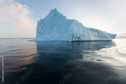 Icebergs in front of the fishing town Ilulissat in Greenland. Nature and landscapes of Greenland. Travel on the vessel among ices. Phenomenon of global warming. Ices of unusual forms and colors.  © Michal