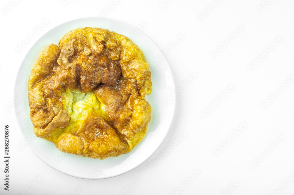 Top view traditional thai style omelet in ceramic plate on white background and copy space. Top view traditional thai style omelet in ceramic plate on white background and copy space.