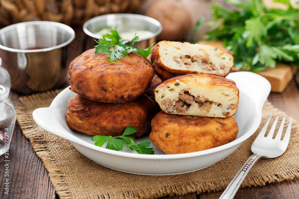 Potato patties (zrazy) Stuffed with minced meat, served with sour cream and tomato sauce.