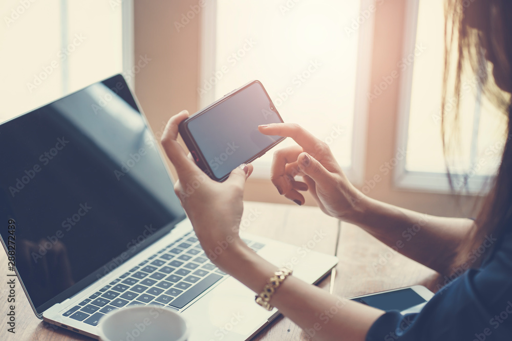 Obraz premium Woman using smart phone while working in the coffeeshop. Modern and smart lifestyle with online mobile technology.