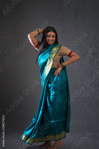 young woman dancing in saree	 photo