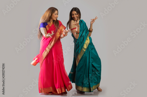 young women dancing in saree	 photo