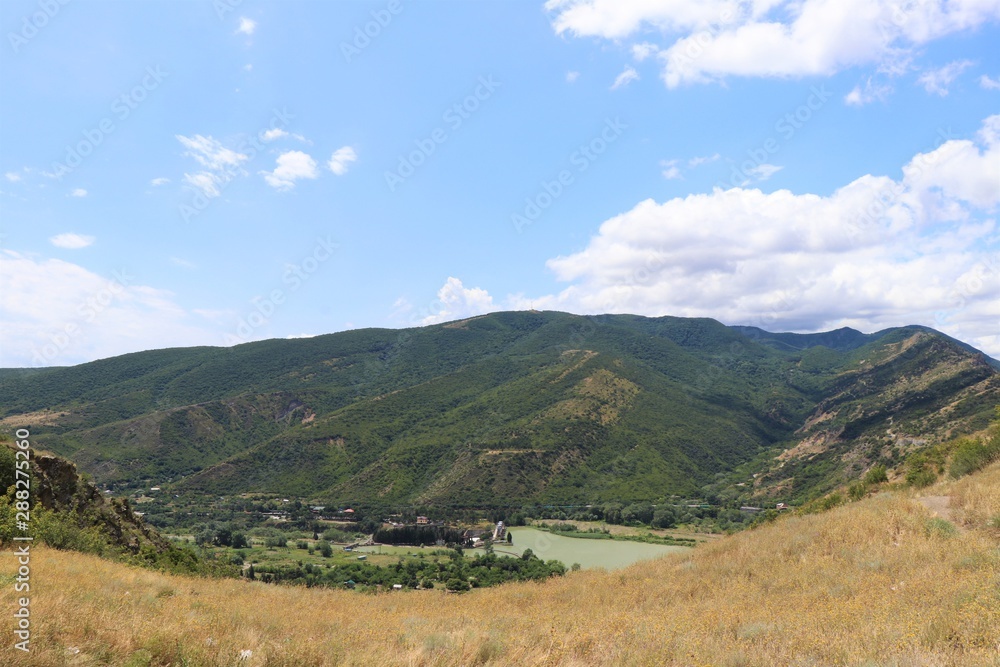 Aerial panoramic view of Mtskheta village, near Tbilisi, where the Aragvi river flows into the Kura river. View from the Jvary monastery hill. The Mtskheta village is part of the UNESCO heritage site.