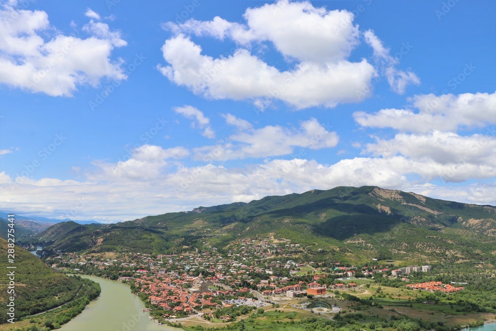 Aerial panoramic view of Mtskheta village, near Tbilisi, where the Aragvi river flows into the Kura river. View from the Jvary monastery hill. The Mtskheta village is part of the UNESCO heritage site.