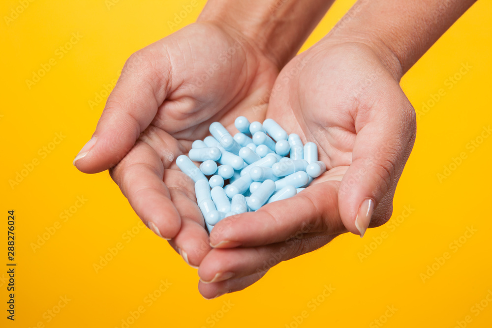 medicine for reduce cold fever in hand with yellow background copy space for text