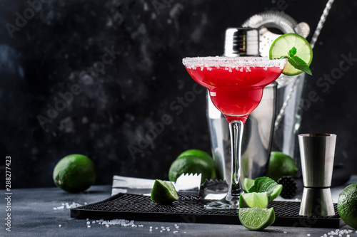 Watermelon margarita, alcoholic cocktail with silver tequila, lime juice, mint, watermelon and crushed ice, metal bar tools, gray background photo